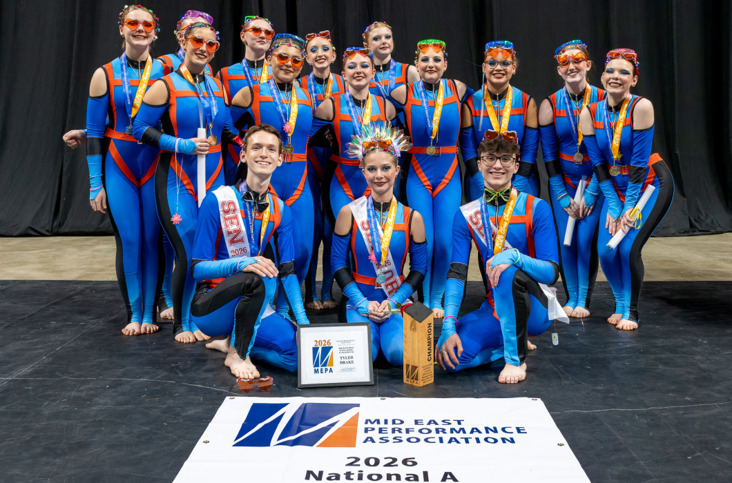 Franklin High School Winter Guard, wearing blue uniforms, pose behind a sign noting they are the National A Champions.